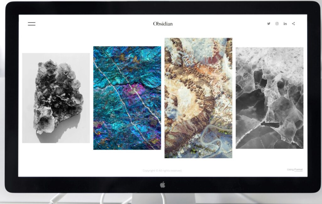 A contemporary office desk setup featuring a sleek computer monitor displaying abstract artwork.